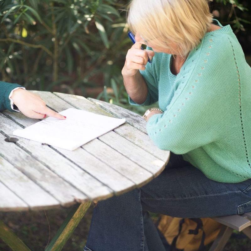 femme-attablée-devant-feuille